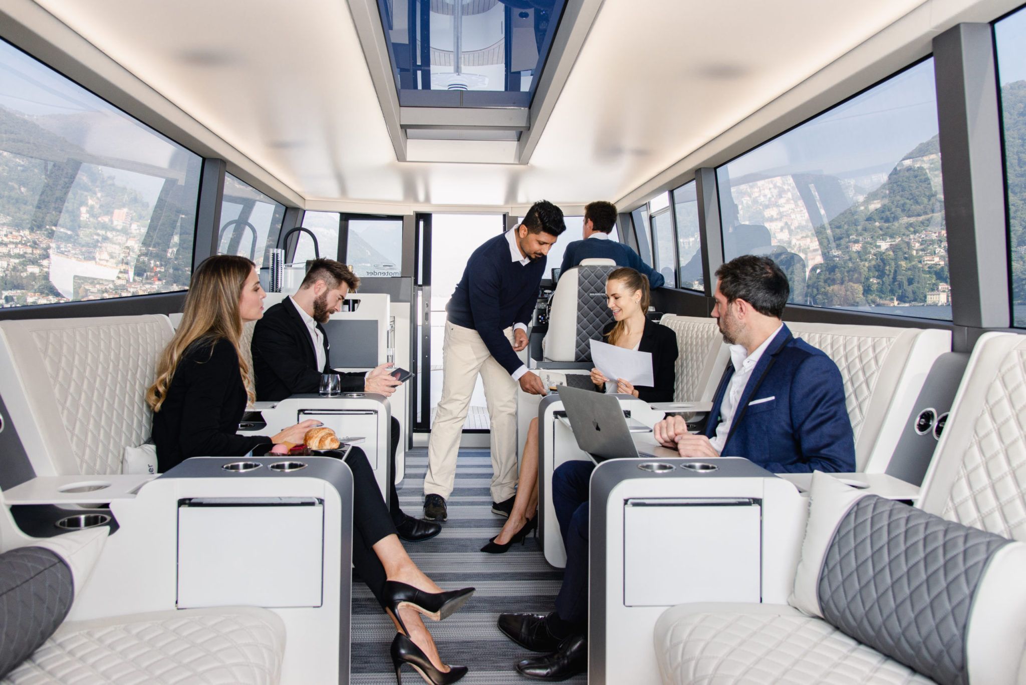 A business meeting in lake como on a private boat tour on the lake this is the right venue for your meeting on the lake and the waiter is offering coffee and sweets