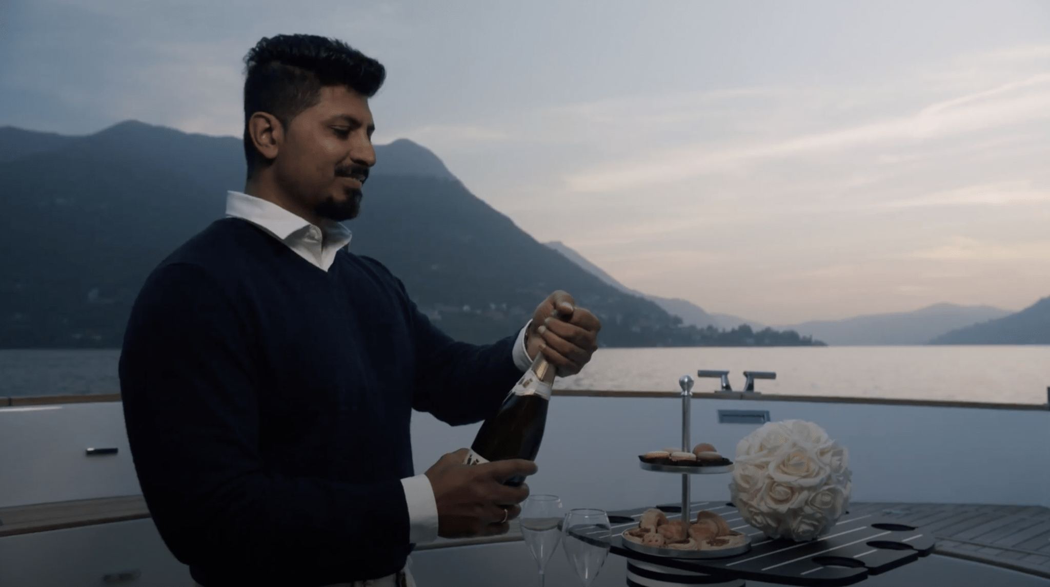 wedding boats in como with service on board for a high-end wedding in Italy - for a private tour of the lake a waitier is offering exclusive wine to the newlyweds