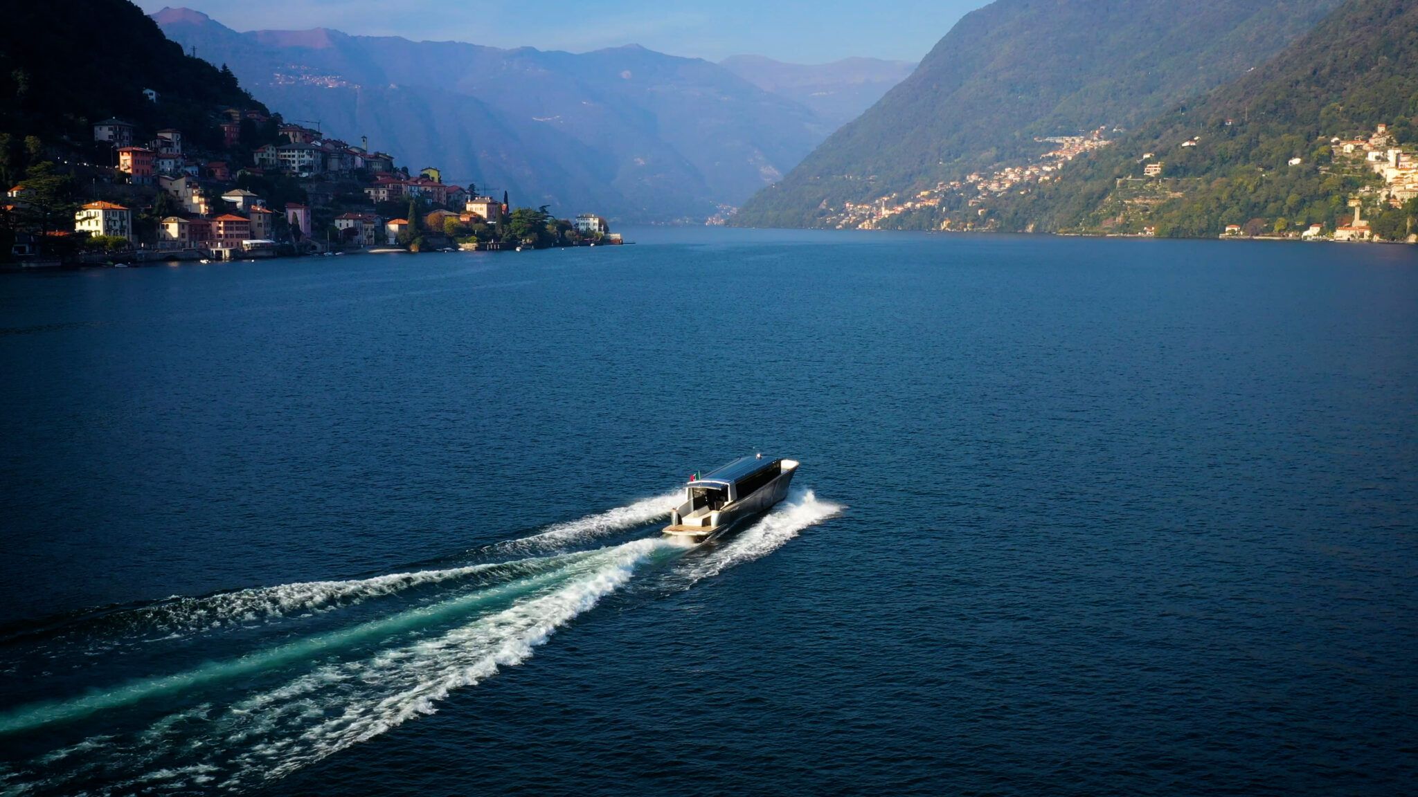 Limotender naviga sul Lago di Como con vista panoramica su ville, paesi e montagne.